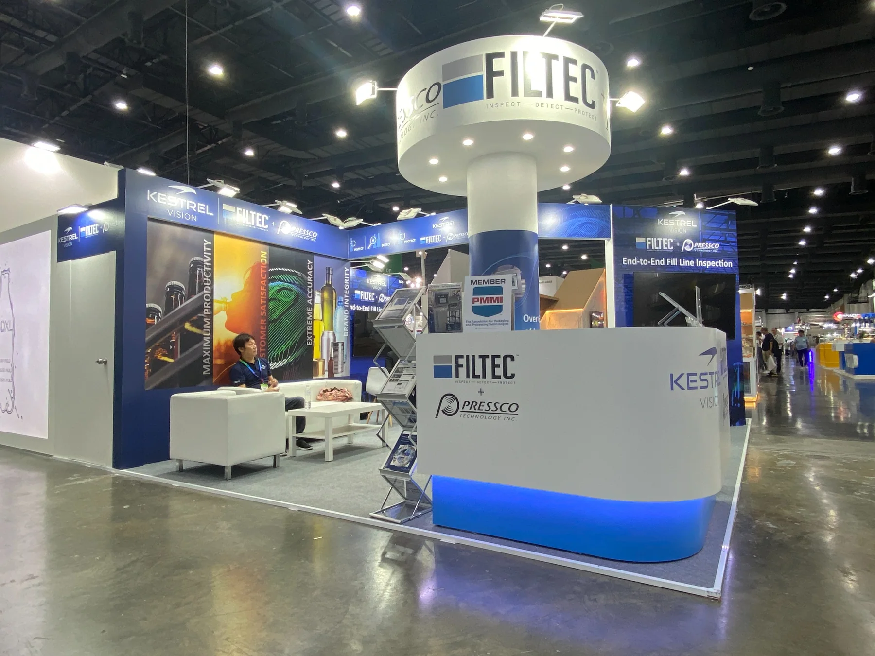 FILTEC booth reception counter, lounge seating and circular branded tower